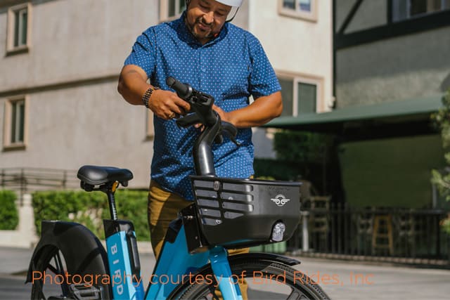 guy getting on a bird scooter